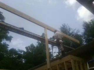 Carpenter setting a ridge beam over a new addition frame — Ice Dam Removal by Roofing Brothers in Rohrersville